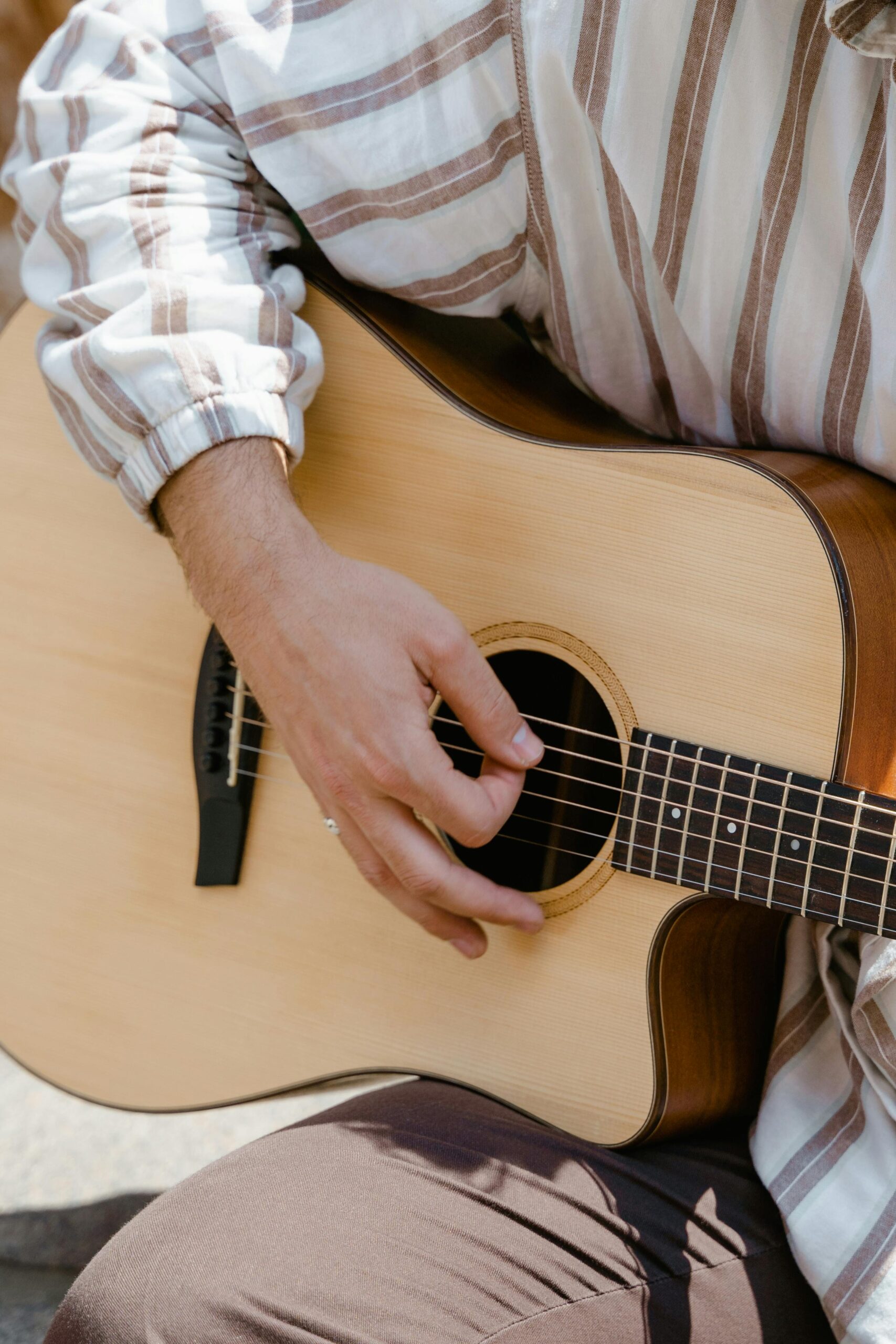 Person Holding Brown Acoustic Guitar